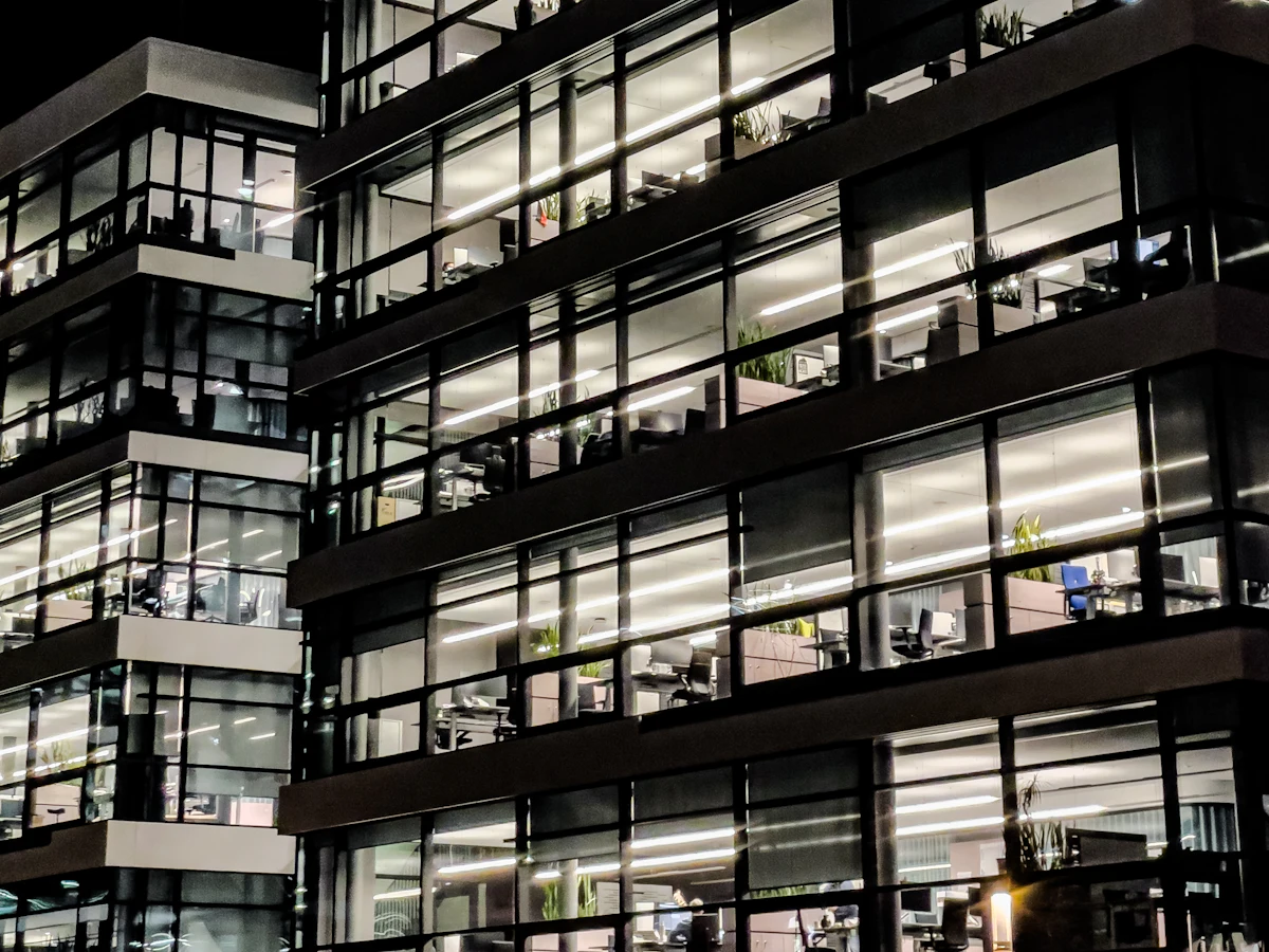 Lit office tower windows in a business district at night